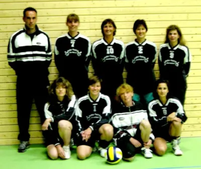Damenmannschaft in schwarzen Trikots mit Trainer